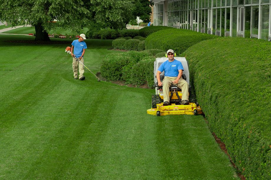 n_033.jpg_1682624361 A man riding on the back of a lawn mower.