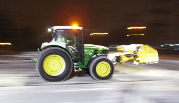 winter_work_3.jpg_1682623942 A tractor is driving down the road at night.