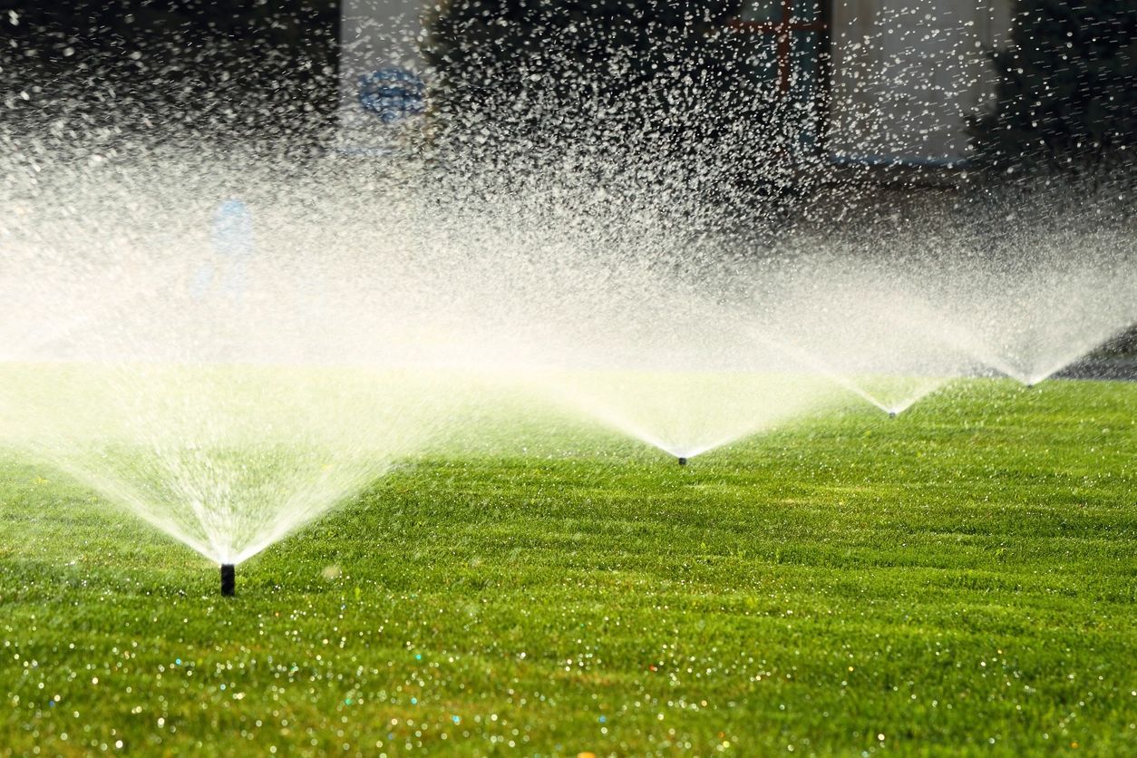 fm=f_PeyDPW1.jpg_1684446964 A lawn with sprinklers spraying water on it.